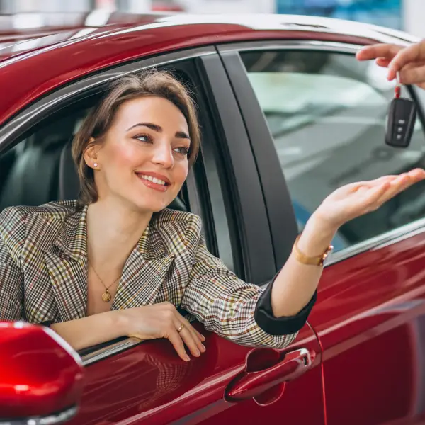 woman-sitting-red-car-receiving-keys